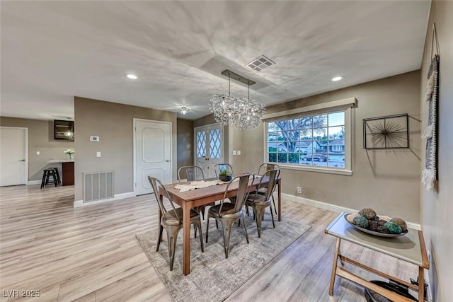 dining area with a chandelier and light hardwood / wood-style floors