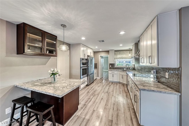 kitchen featuring pendant lighting, sink, tasteful backsplash, and white cabinets