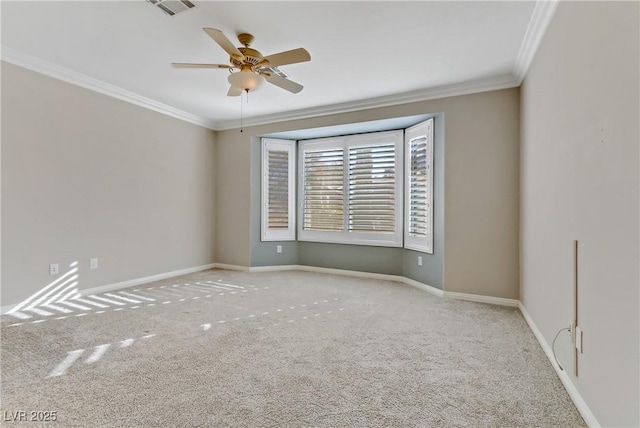 empty room featuring ceiling fan, light colored carpet, and crown molding