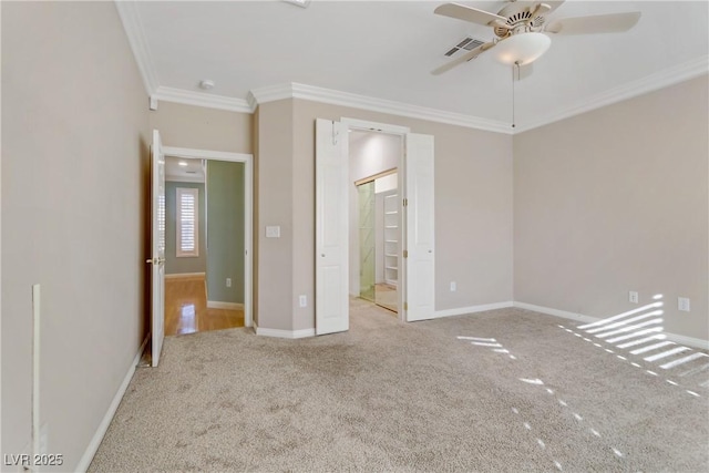 unfurnished bedroom featuring ceiling fan, crown molding, and light carpet