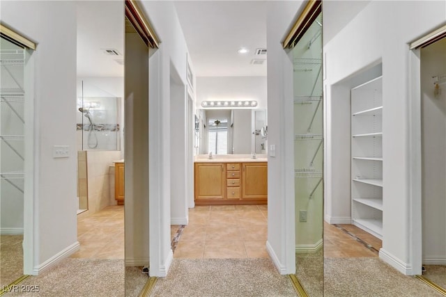 bathroom with vanity, walk in shower, and tile patterned flooring