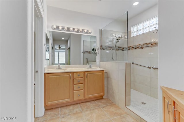 bathroom featuring tiled shower, tile patterned floors, and vanity