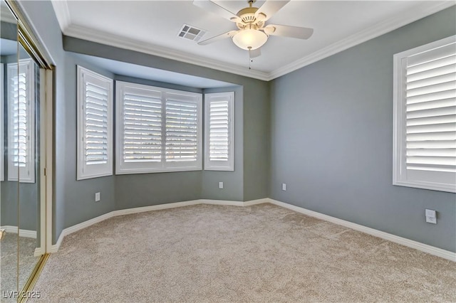 carpeted spare room with crown molding and ceiling fan