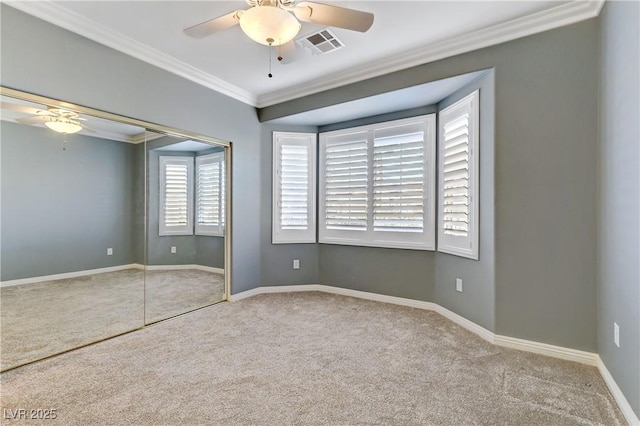 carpeted spare room with ceiling fan and crown molding