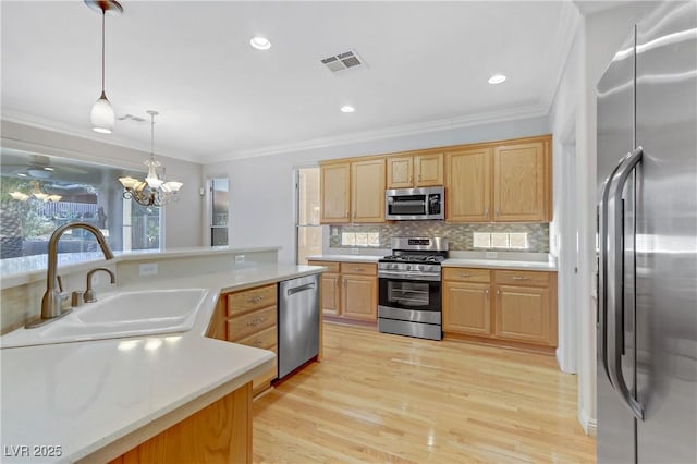 kitchen featuring appliances with stainless steel finishes, sink, decorative light fixtures, ornamental molding, and backsplash