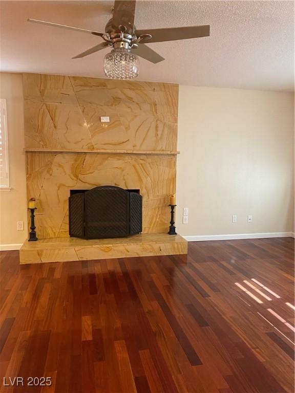 details featuring wood-type flooring, a textured ceiling, a fireplace, and ceiling fan