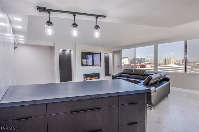 kitchen with dark brown cabinetry, light tile patterned floors, and pendant lighting