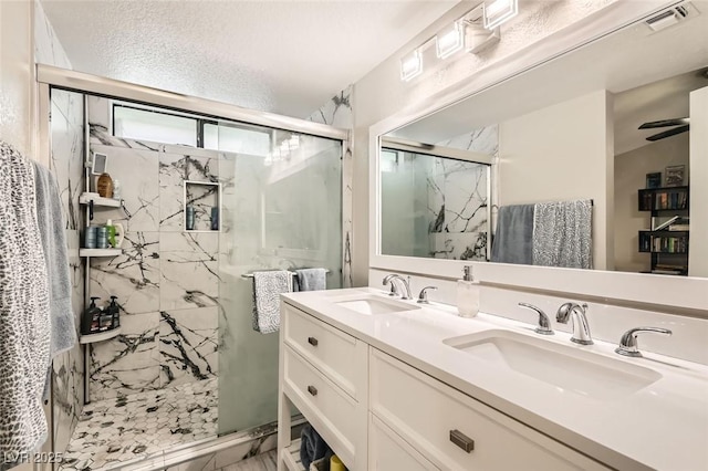 bathroom with vanity, a textured ceiling, an enclosed shower, and ceiling fan