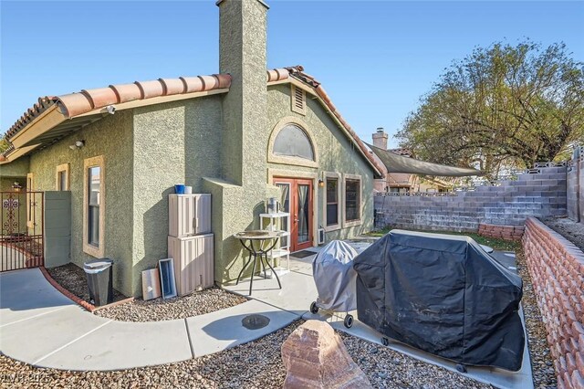 back of property featuring a patio area, fence, a tile roof, and stucco siding