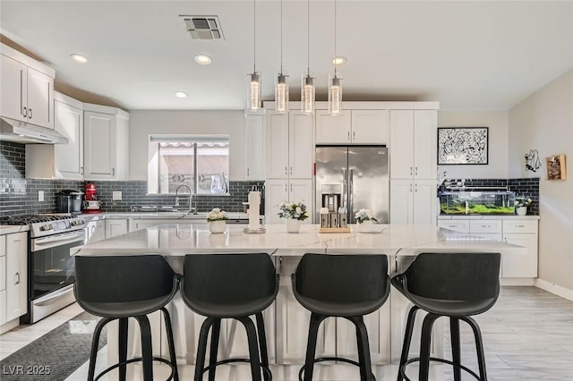 kitchen featuring white cabinetry, stainless steel appliances, and a kitchen island