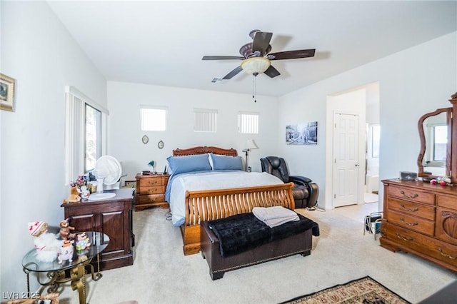 carpeted bedroom with ceiling fan and ensuite bath