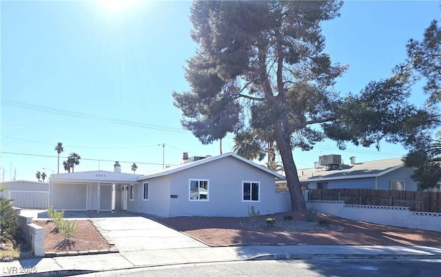 view of front facade with cooling unit and a carport