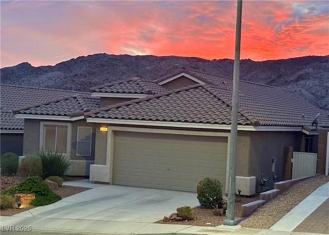 view of front of property with a mountain view and a garage