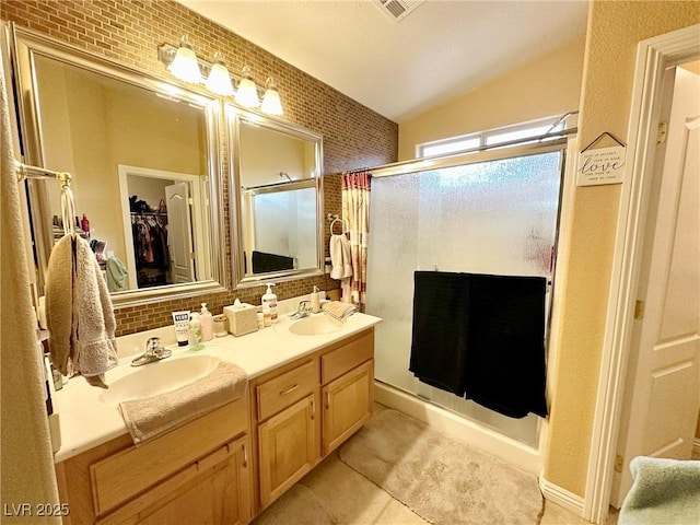 bathroom featuring a shower with shower door, lofted ceiling, backsplash, tile patterned floors, and vanity