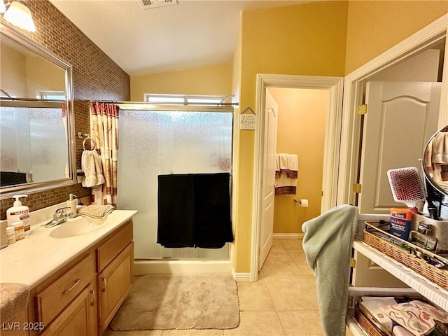 bathroom with vaulted ceiling, vanity, walk in shower, tile patterned flooring, and tasteful backsplash