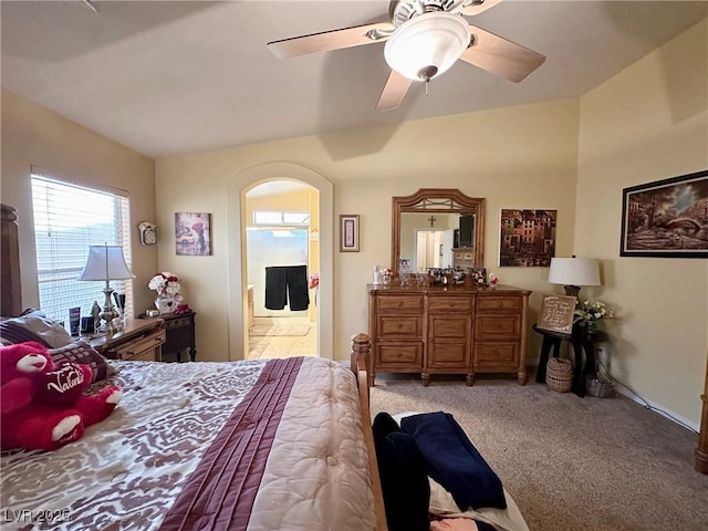 bedroom with ensuite bath, ceiling fan, and carpet floors