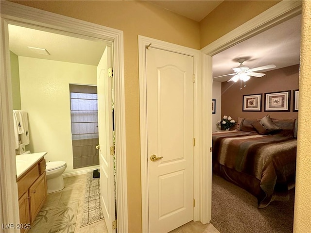 bedroom with ceiling fan and ensuite bath