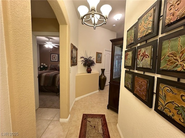 corridor with light tile patterned floors and a chandelier