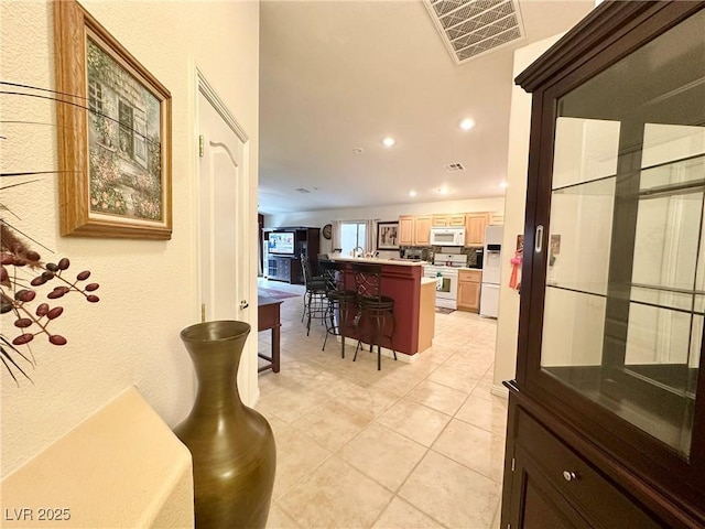 kitchen featuring white appliances and light tile patterned flooring