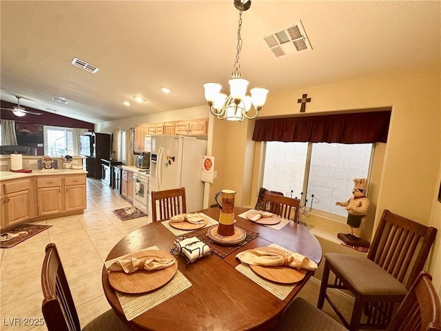 dining space featuring light tile patterned flooring, a chandelier, and lofted ceiling