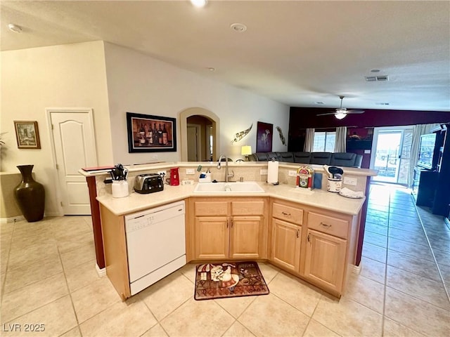 kitchen with a center island with sink, white dishwasher, light brown cabinets, light tile patterned floors, and sink