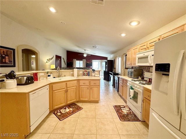 kitchen with white appliances, light tile patterned floors, sink, lofted ceiling, and light brown cabinets