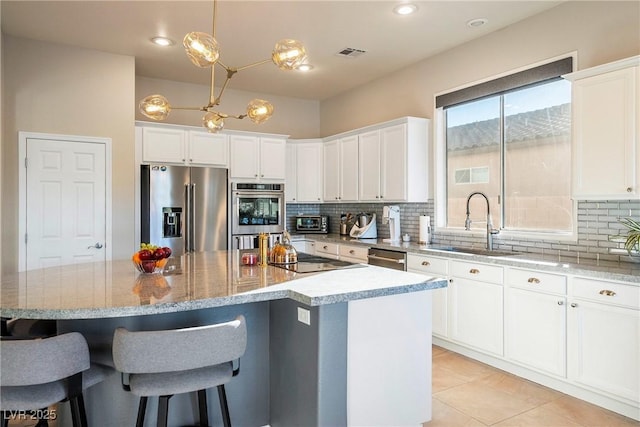 kitchen featuring white cabinetry, stainless steel appliances, a kitchen island, and pendant lighting