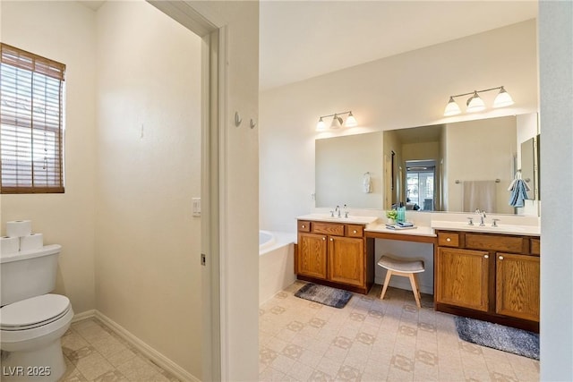 bathroom with vanity, toilet, and a tub to relax in