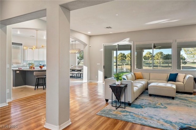 living room featuring an inviting chandelier and light wood-type flooring