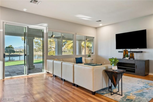 living room featuring hardwood / wood-style floors and a water view