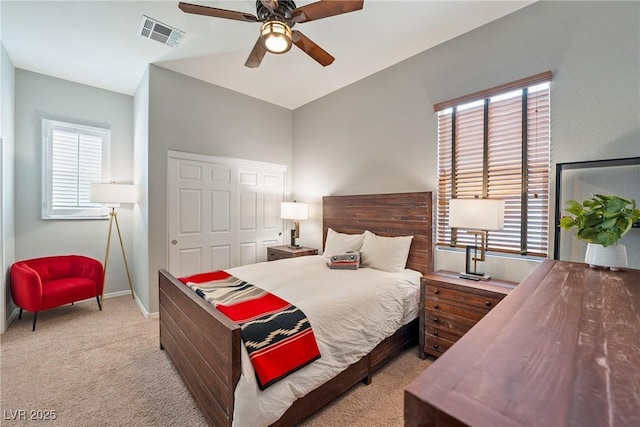 bedroom with vaulted ceiling, light carpet, ceiling fan, and a closet