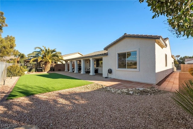 back of house featuring a yard and a patio area