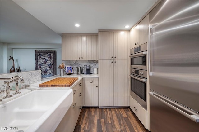 kitchen with sink, dark wood-type flooring, tasteful backsplash, and stainless steel built in refrigerator