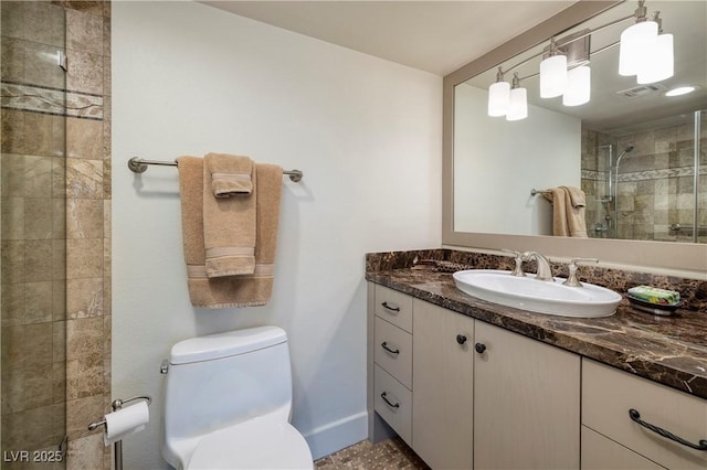 bathroom featuring toilet, an enclosed shower, and vanity