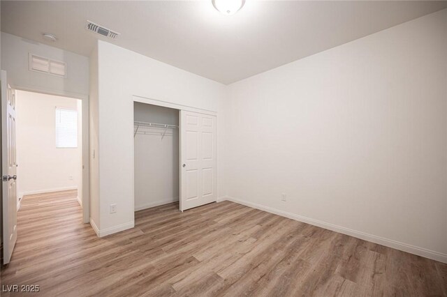 unfurnished bedroom featuring light hardwood / wood-style floors and a closet