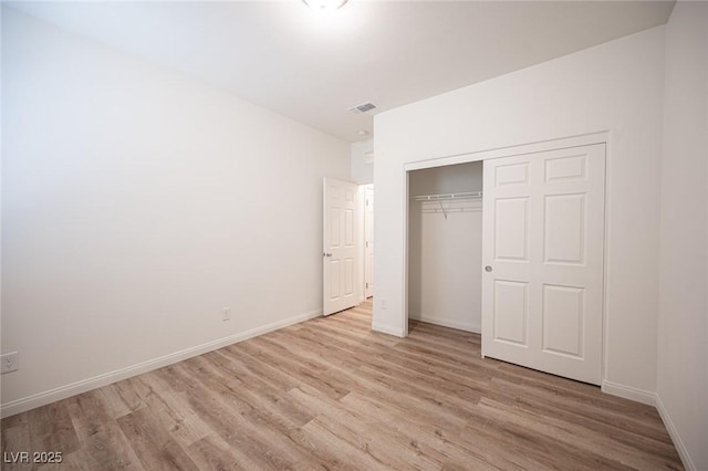 unfurnished bedroom featuring light wood-type flooring and a closet