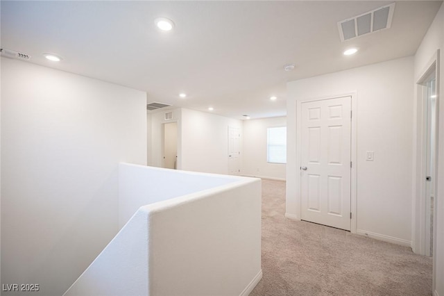 hall featuring light colored carpet