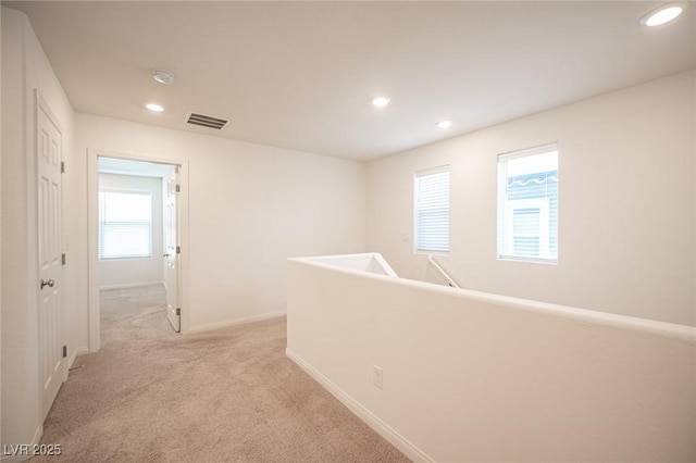 hallway with light colored carpet