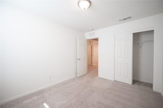 unfurnished bedroom with a closet and light carpet