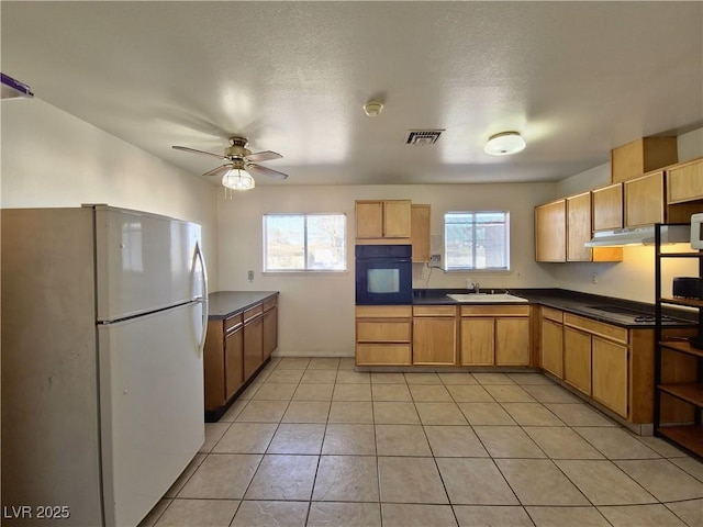 kitchen with white refrigerator, sink, oven, ceiling fan, and light tile patterned floors