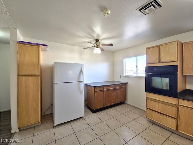 kitchen with ceiling fan, light tile patterned floors, oven, and white fridge