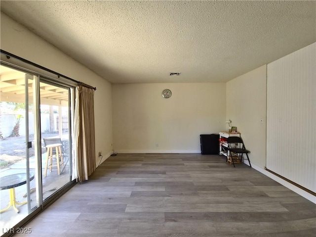 empty room featuring hardwood / wood-style floors and a textured ceiling