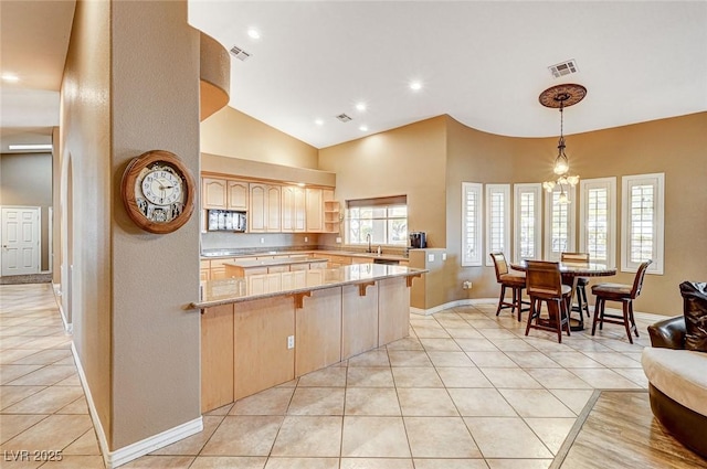 kitchen with light brown cabinetry, sink, kitchen peninsula, and light tile patterned flooring