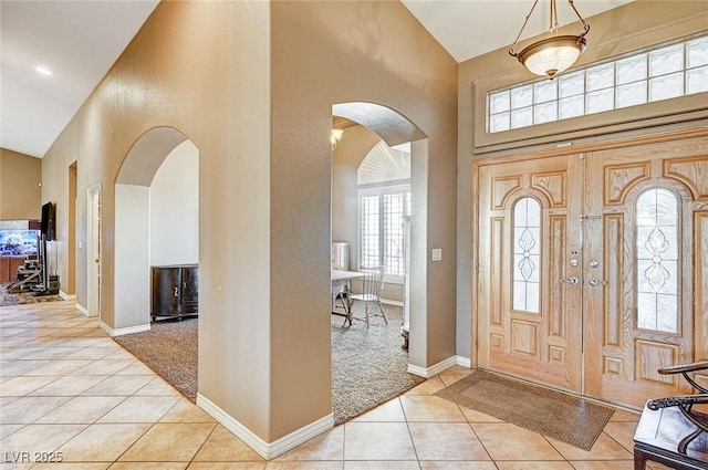 entrance foyer with a high ceiling and light carpet