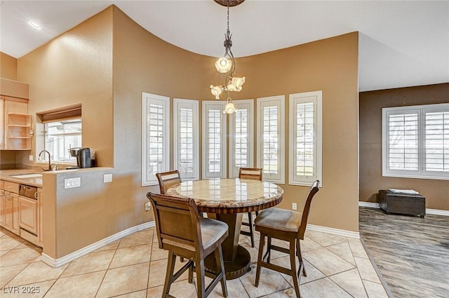 dining area with sink, light tile patterned floors, and a notable chandelier