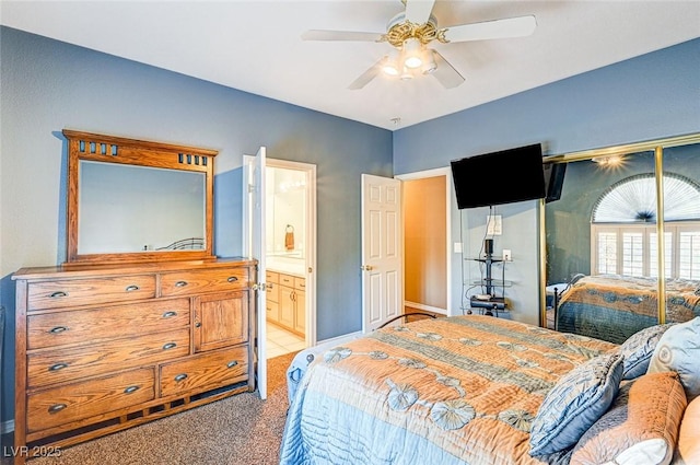 bedroom with ceiling fan, ensuite bathroom, and carpet flooring