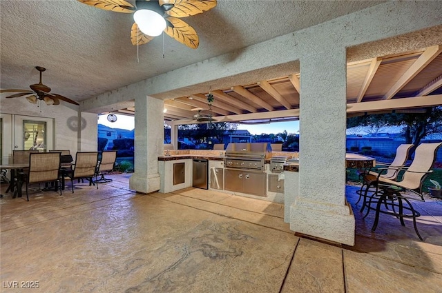 view of patio featuring ceiling fan, an outdoor kitchen, and a grill