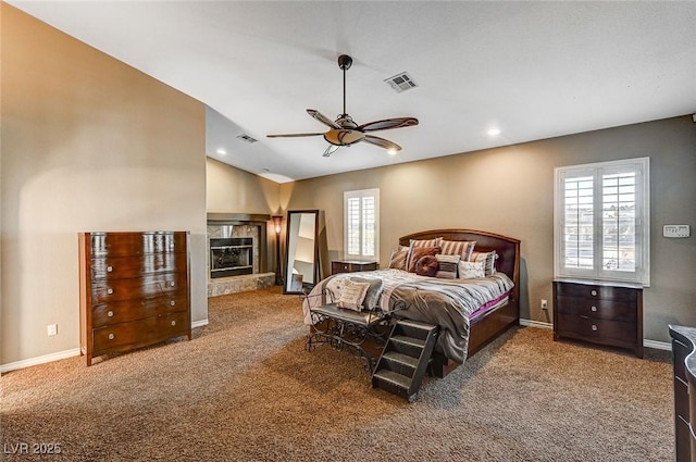 carpeted bedroom featuring ceiling fan, lofted ceiling, and a fireplace