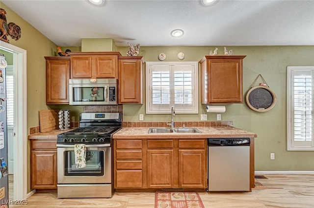 kitchen featuring sink, appliances with stainless steel finishes, and a healthy amount of sunlight