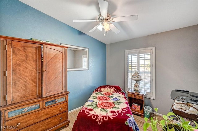 bedroom with ceiling fan, light hardwood / wood-style flooring, and lofted ceiling